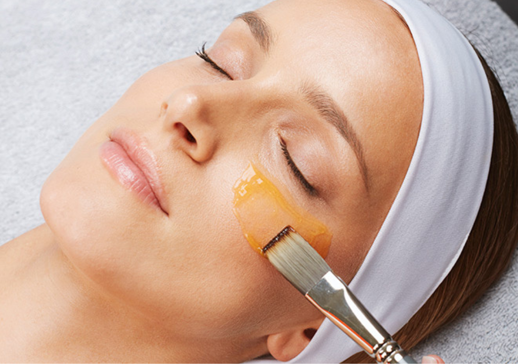 Woman getting under eye treatment with a serum and brush